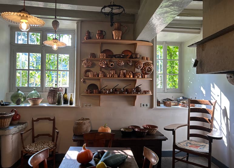 La cuisine du château de Saint-Point, avec ses récipients en cuivre et quelques légumes disposés sur la table.